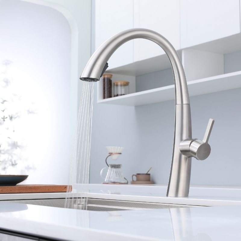 Robinet de cuisine contemporain en nickel brossé avec bec col de cygne à grand arc et douchette extractible. Idéal pour les cuisines modernes.