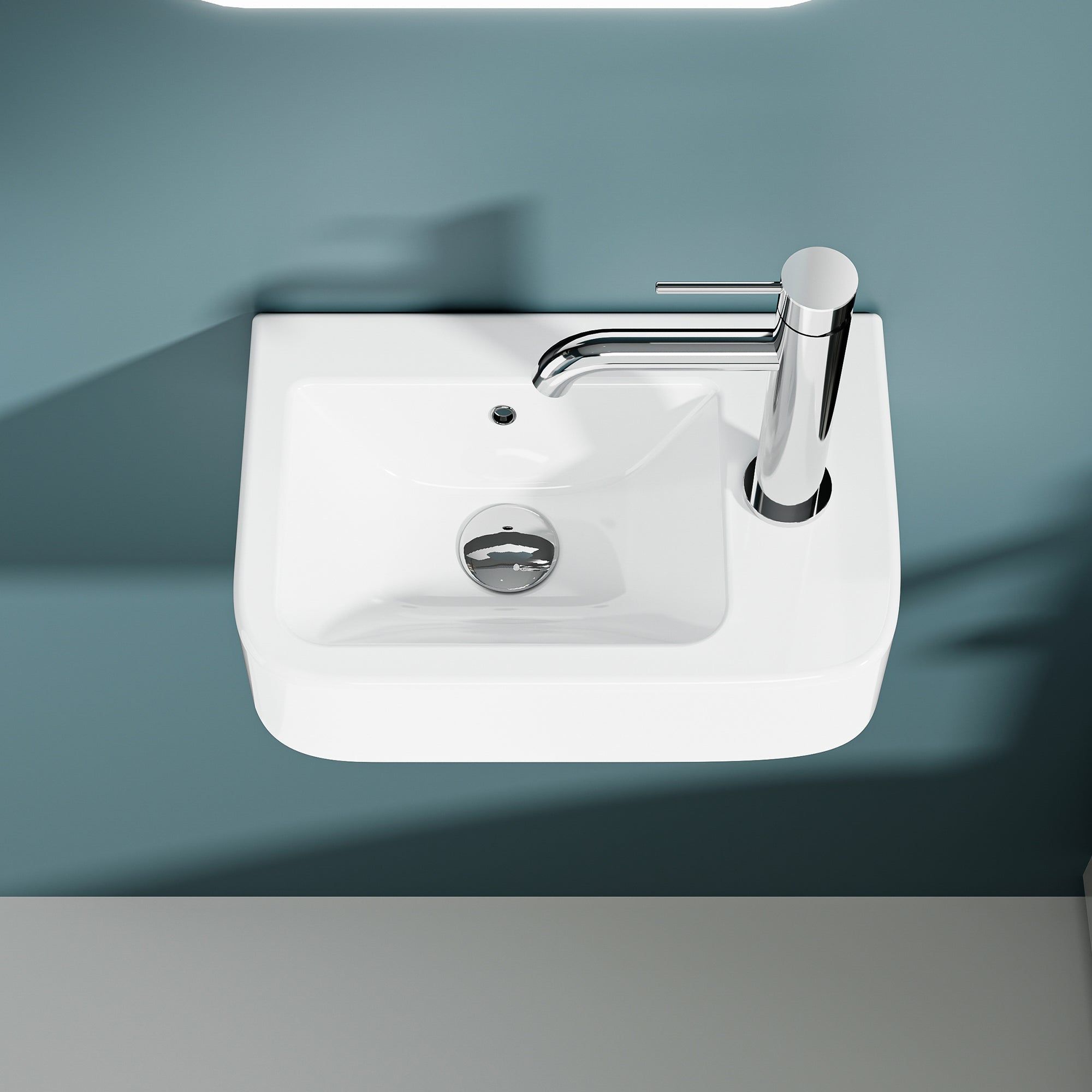 Lavabo mural compact blanc en céramique avec robinet chromé à sortie droite.