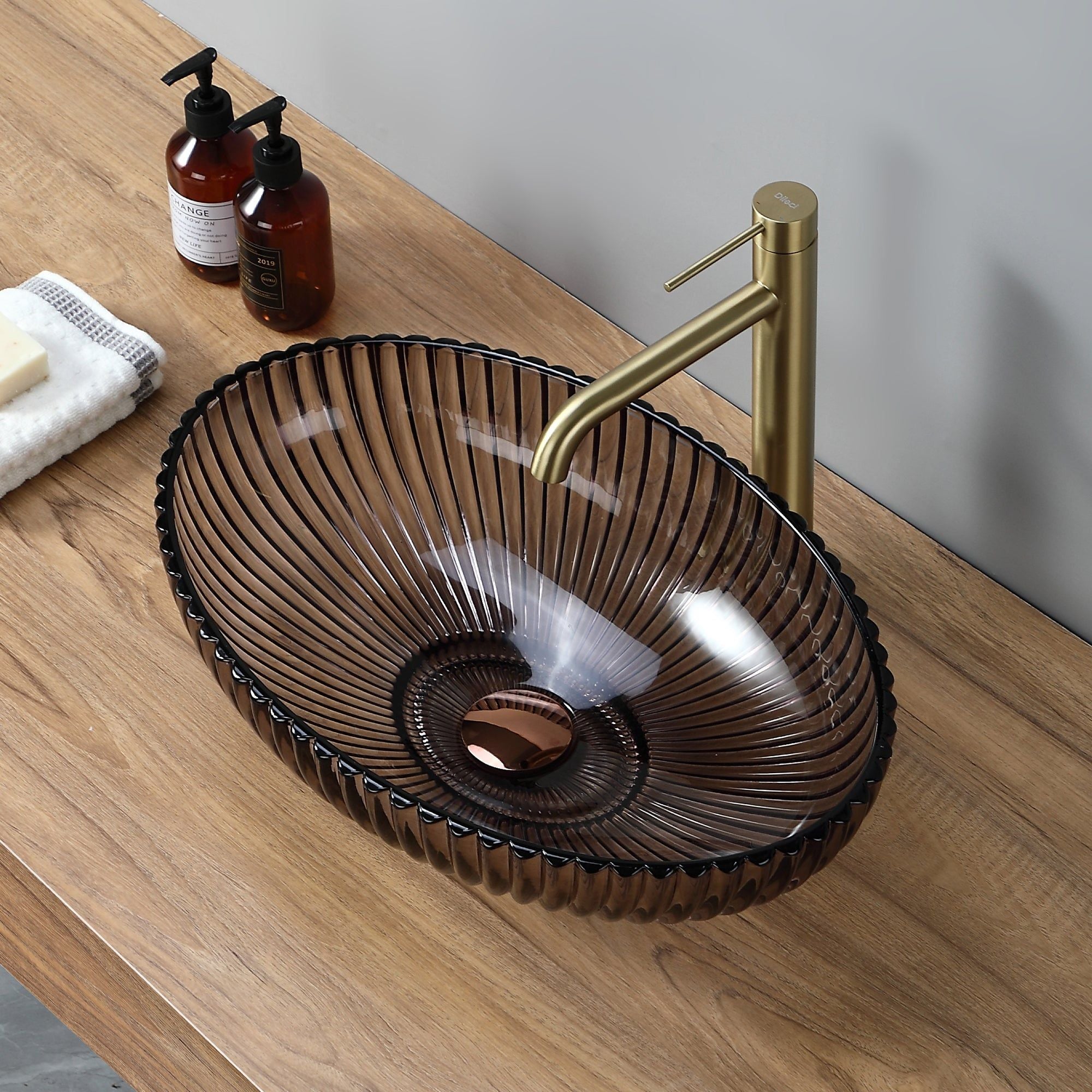 Lavabo ovale en verre marron rayé (51 × 35 × 15,5 cm) avec robinetterie dorée. Meuble-lavabo moderne.