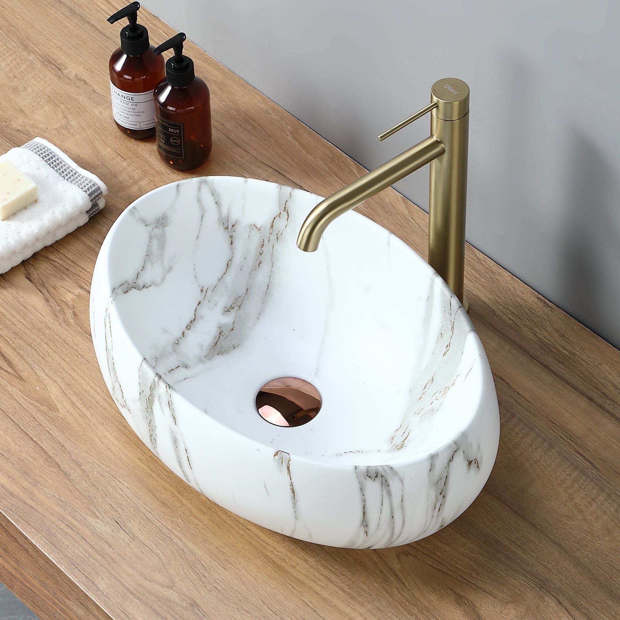 Vasque ovale effet marbre blanc (48 x 35 cm). Lavabo de salle de bain moderne avec robinetterie dorée.