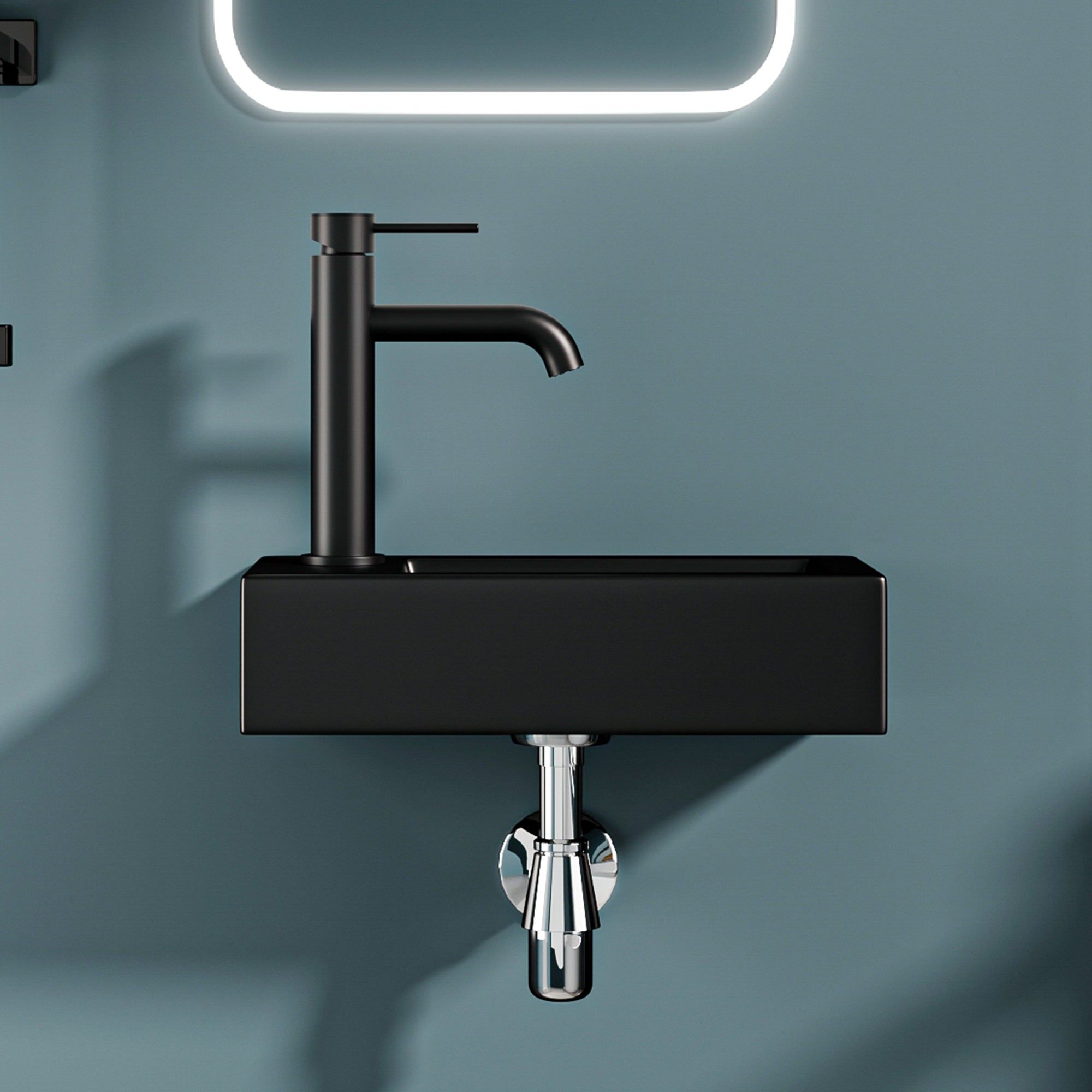 Lavabo mural noir mat avec drain à gauche et robinet noir minimaliste.