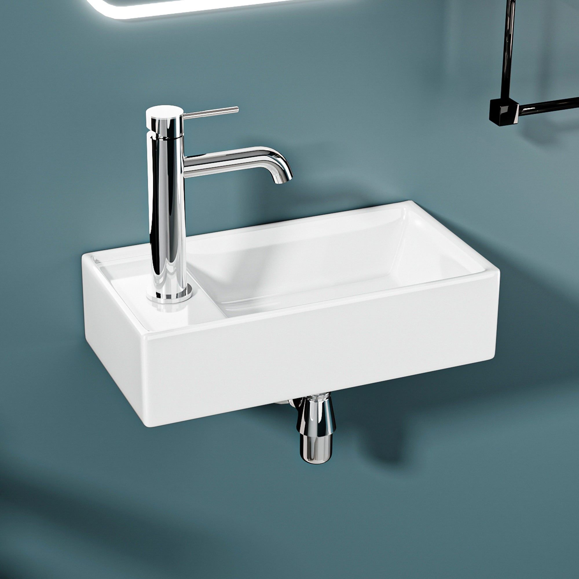 Lavabo mural avec robinet chromé. Design compact, idéal pour les petits espaces.