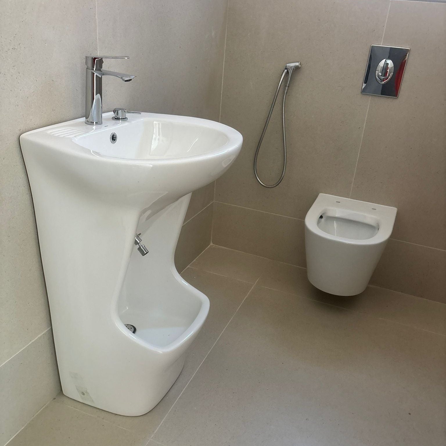 Lavabo d'ablutions Méca avec bassin de lavage des pieds et toilettes suspendues en céramique blanche.