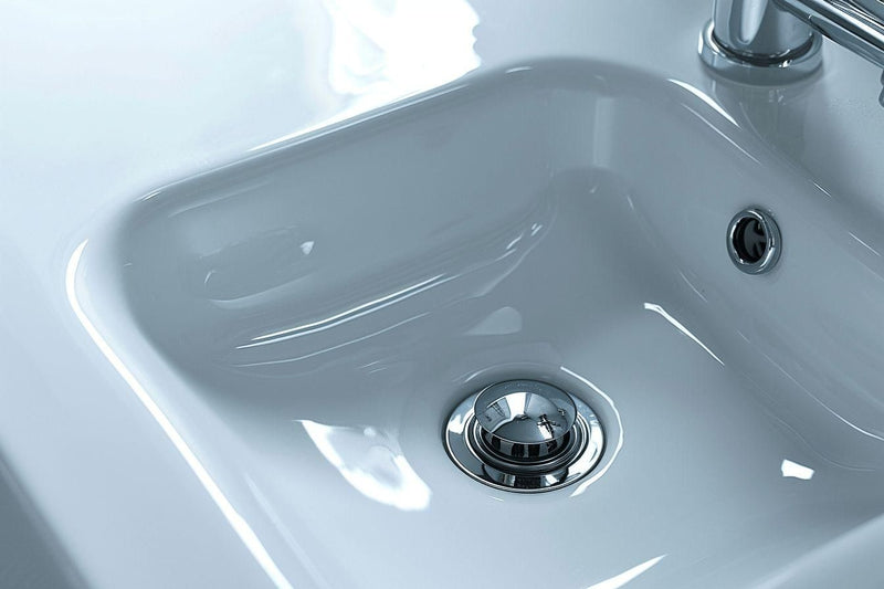 Gros plan sur un lavabo de salle de bain en acier chromé.