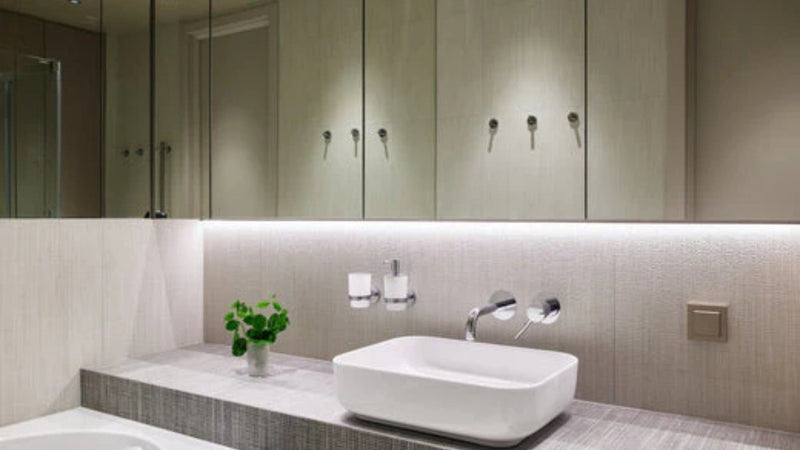 Éclairage salle de bains sans fenêtre : lavabo moderne, armoires et astuces anti-humidité.