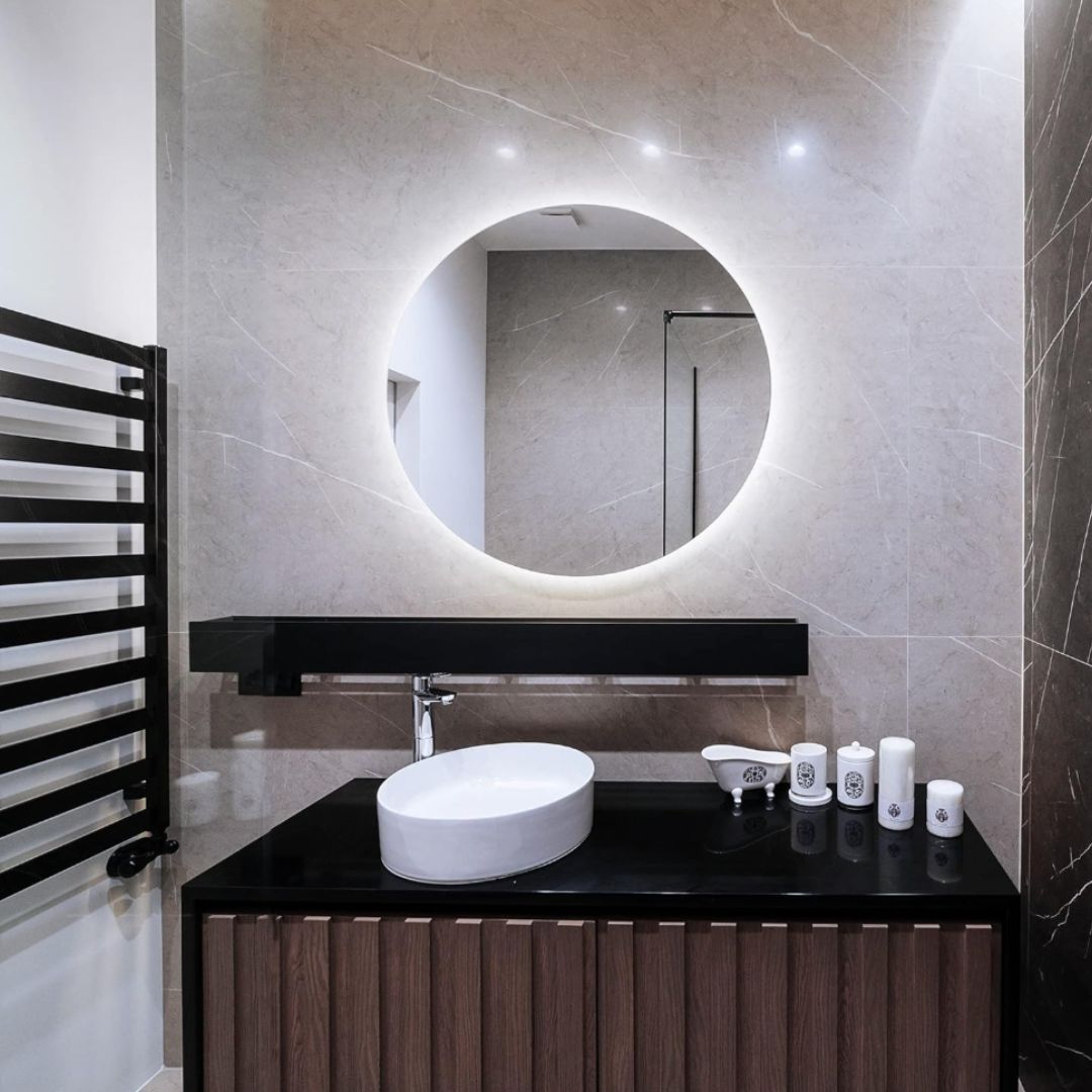 Miroir Infinity LED rond ⌀50cm : Miroir de salle de bain rond éclairé par LED de 50 cm avec cadre noir moderne et meuble vasque.