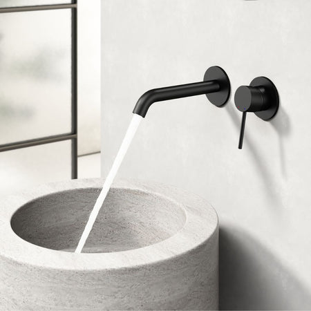 Robinet thermostatique encastré noir mat avec poignée à levier et inverseur séparé. Lavabo de salle de bain moderne et minimaliste.