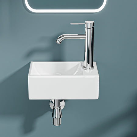 Mini lavabo mural : Lavabo compact en céramique blanche avec robinet chromé, idéal pour les petites salles de bain ou salles d'eau.
