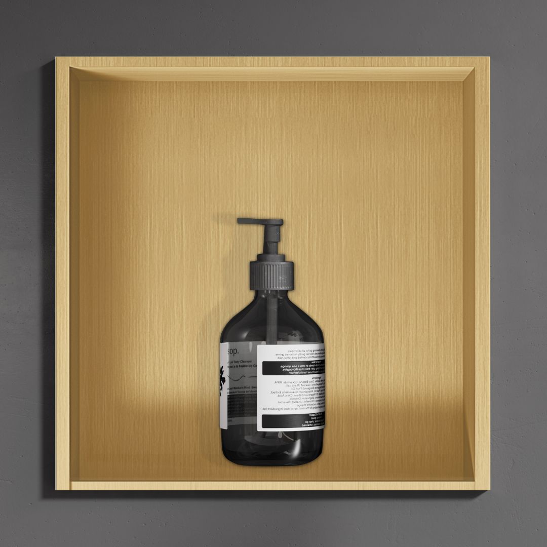 Bouteille de gel douche ambré foncé sur une étagère en bois clair. Niche de douche carrée Or.