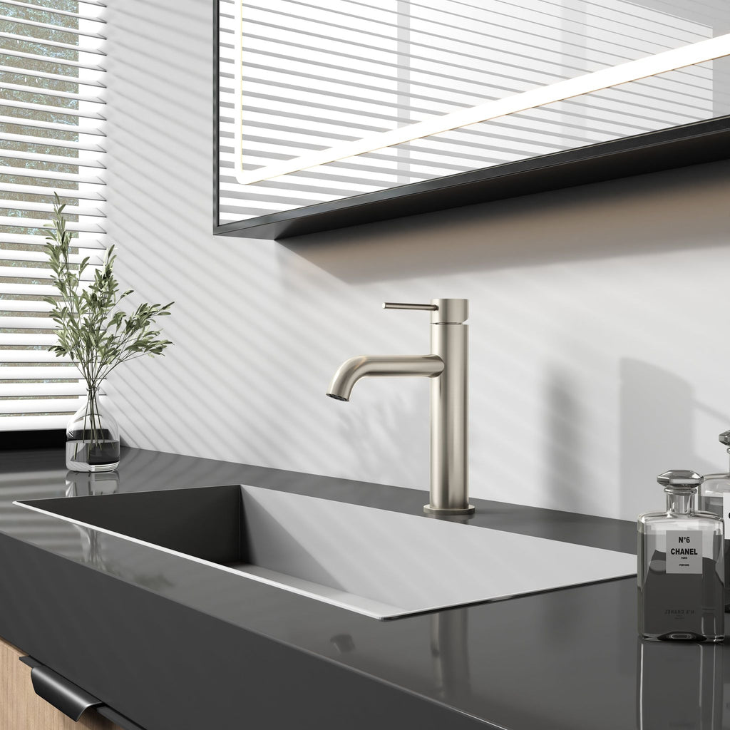 Robinet à bec court - Nickel brossé/Chrome : Robinet de salle de bain moderne en nickel brossé sur un comptoir noir, avec un design élégant