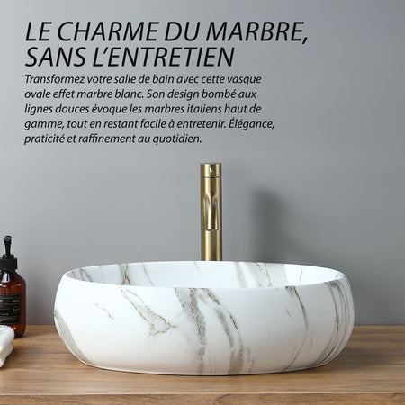 Lavabo ovale effet marbre blanc (48 x 35 cm) avec robinetterie dorée. Design moderne et élégant.